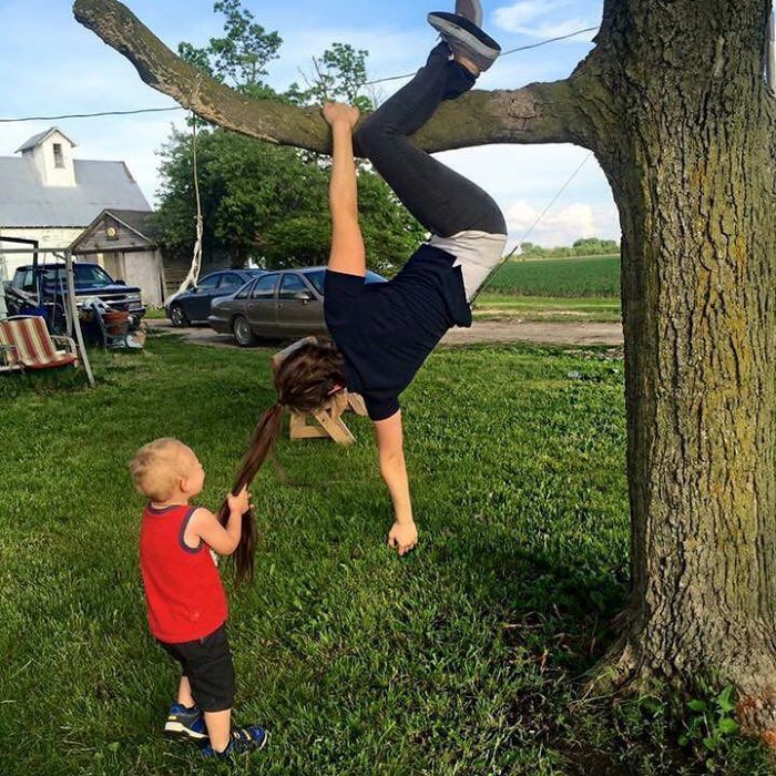 niño jalando el cabello de chica colgando de un árbol