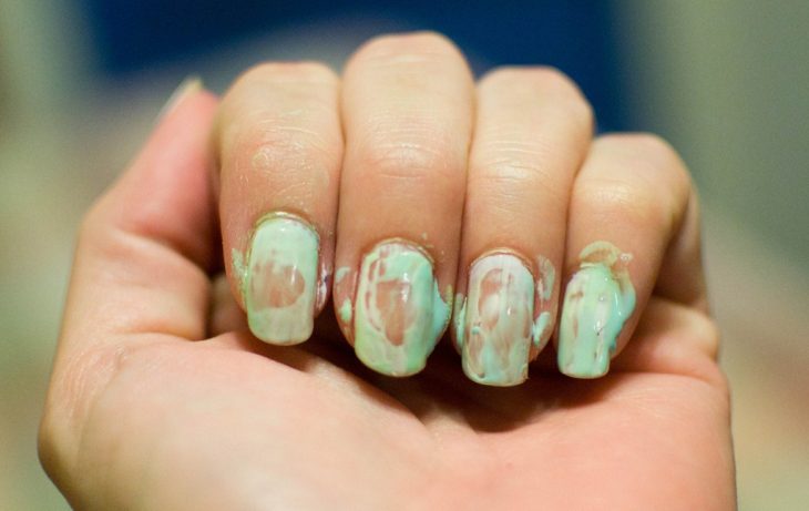 Uñas de una chica arruinadas con el esmalte 