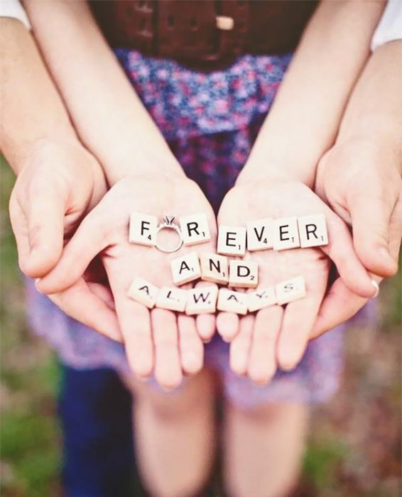 Pareja de novios anunciando su compromiso con piezas des scrabble