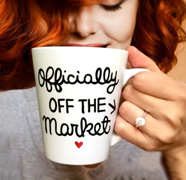 Chica anunciando su compromiso mientras sostiene una taza de café