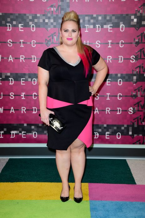 Rebel Wilson usando un vestido en color negro con rosa durante una entrega de premios 