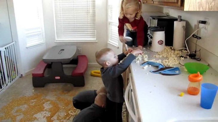 Niños jugando en la cocina.