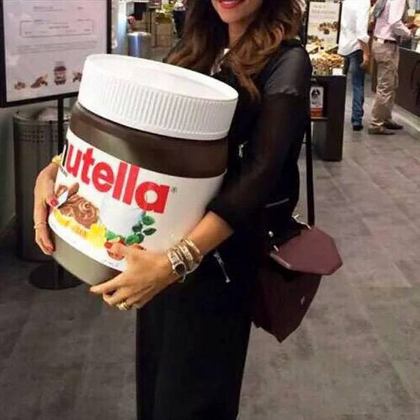Chica cargando un frasco gigante de Nutella 