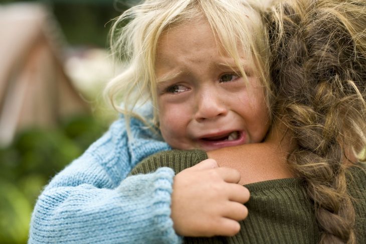 Niña llorando mientras abraza a su madre 