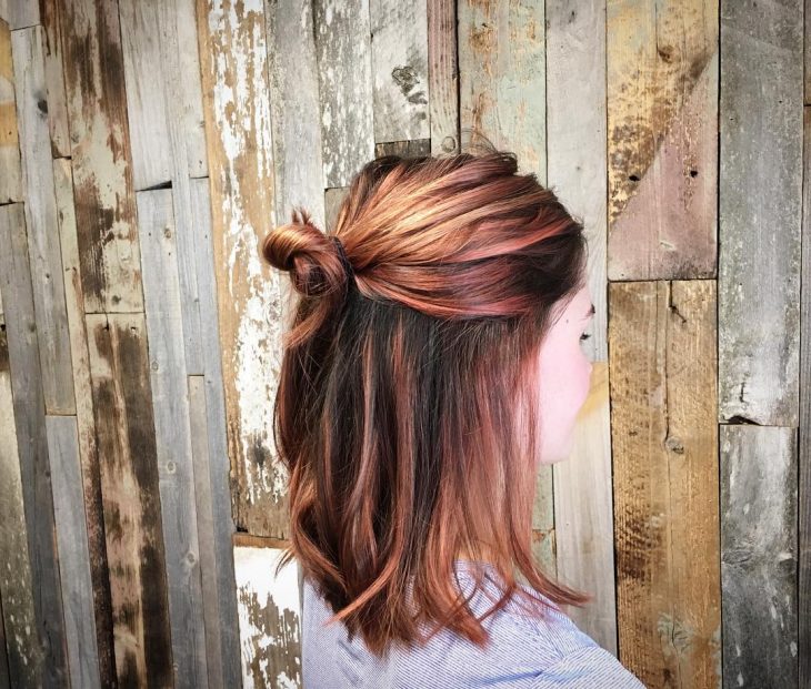 Chica usando un corte de cabello long bob en capas en tonos naranja 