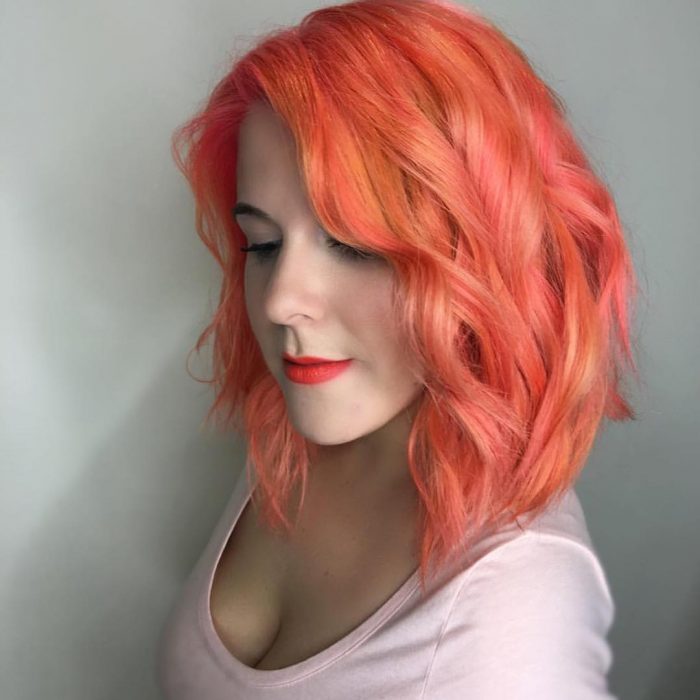 Chica usando un corte de cabello long bob con un tinte en color naranja 