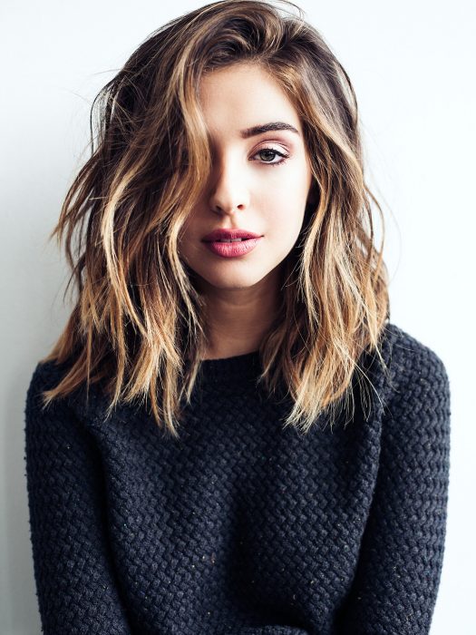 Chica usando un corte de cabello long bob en capas lacio pero despeinado con un tono de tinte de mechas 