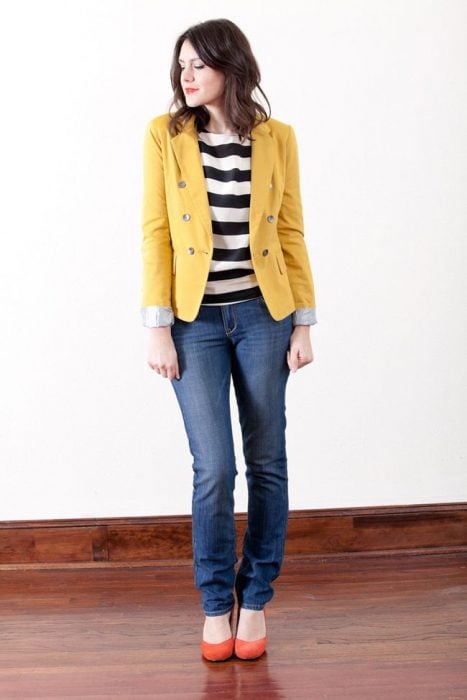 chica con chaqueta amarilla, jeans y tacones naranja
