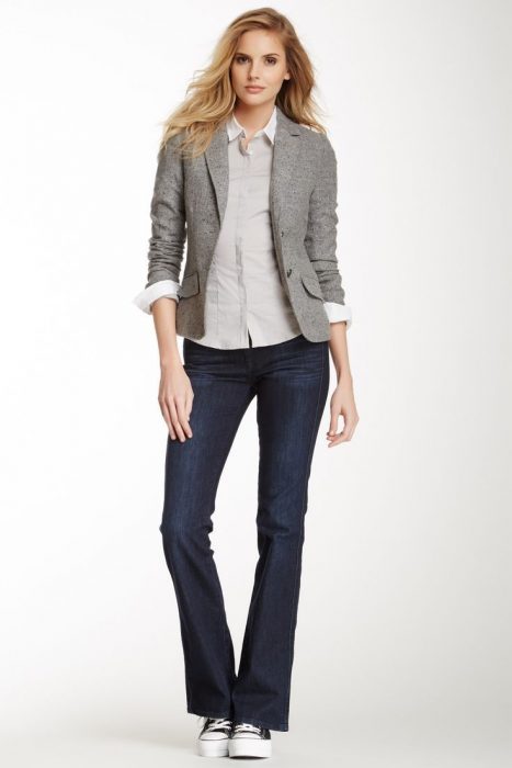 chica con jeans oscuros y blazer gris