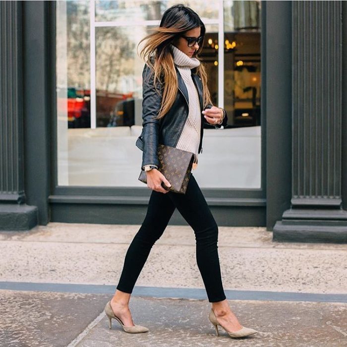 chica con jeans oscuros, tacones y cartera