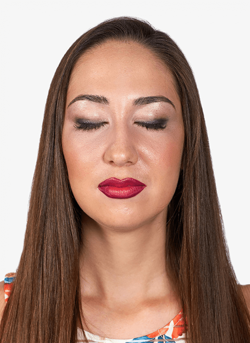 Mujer de cabello largo con los ojos cerrados usando maquillaje Estée Lauder 