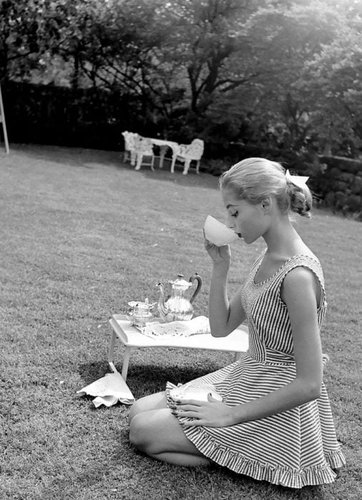 Fotografía de Nina Leen donde aparece una mujer de los años 50 0 60 tomando té en un jardín 