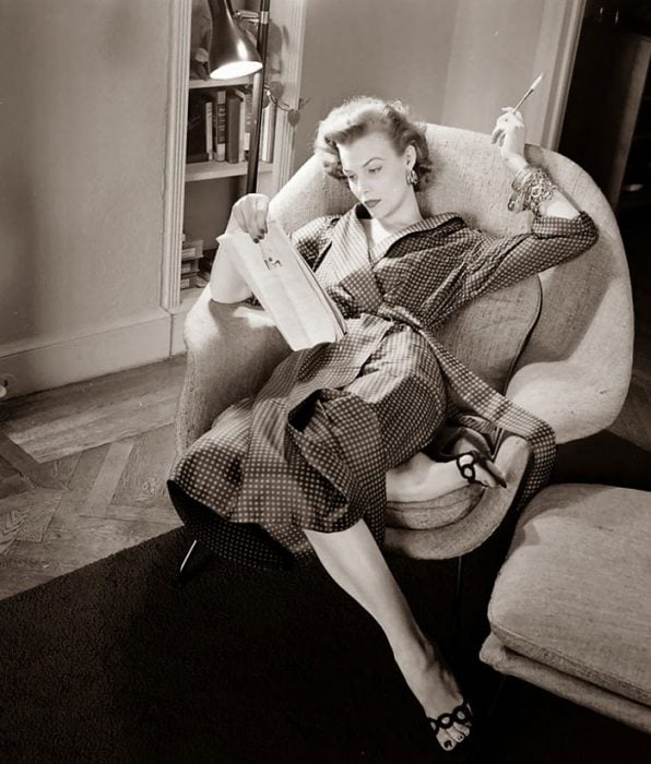 Fotografía de Nina Leen donde aparece una mujer de los años 50 0 60 descansando y leyendo en un sofá 