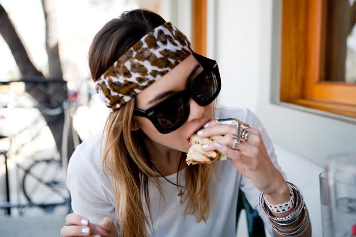 Chica comiendo un sandwich en un restaurante 