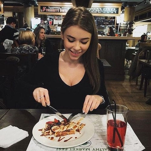 Chica en un restaurante comiendo un postre 