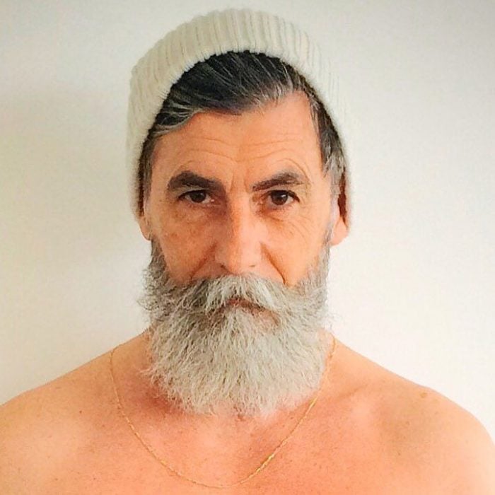 Hombre de 60 años que es modelo posando para una sesión de fotos mientra usa una boina 