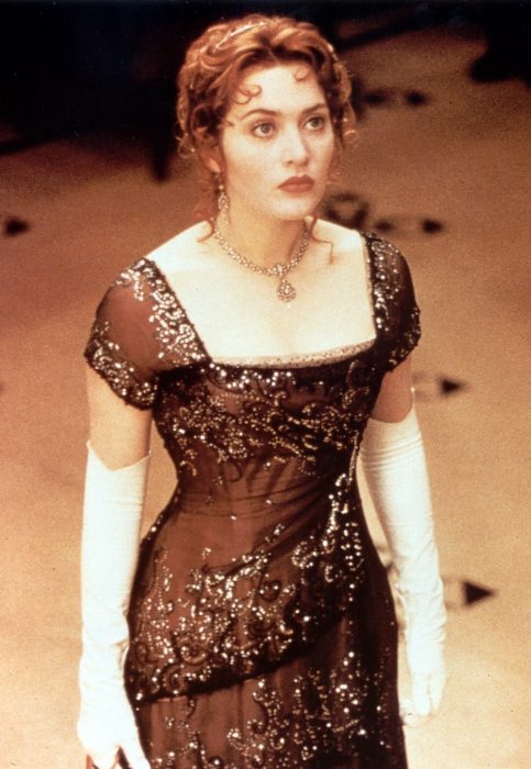 Kate Winslet usando un vestido color café en la película Titanic de 1997