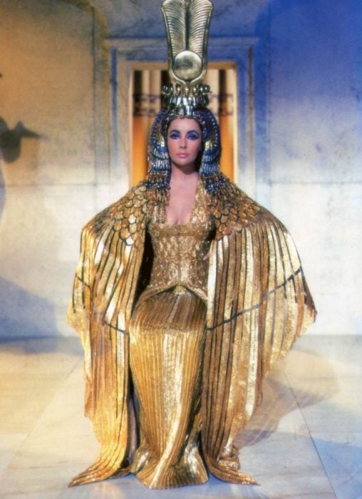Elizabeth Taylor usando un vestido en color dorado durante la película de Cleopatra en 1963