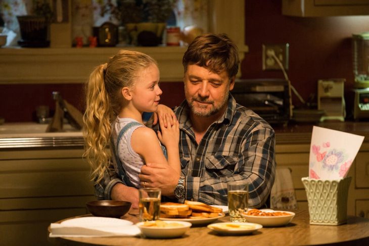 hombre con su hija en brazos en la mesa de la cocina 