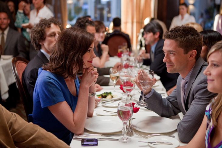 mujer de vestido azul mirando a un hombre durante la cena 