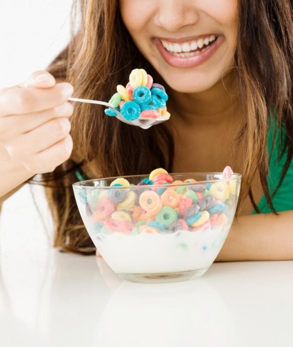 mujer comiendo cereal de niños
