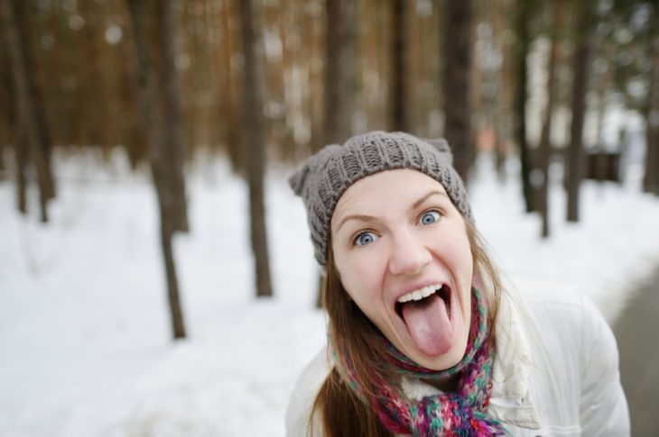 mujer infantil saca la lengua