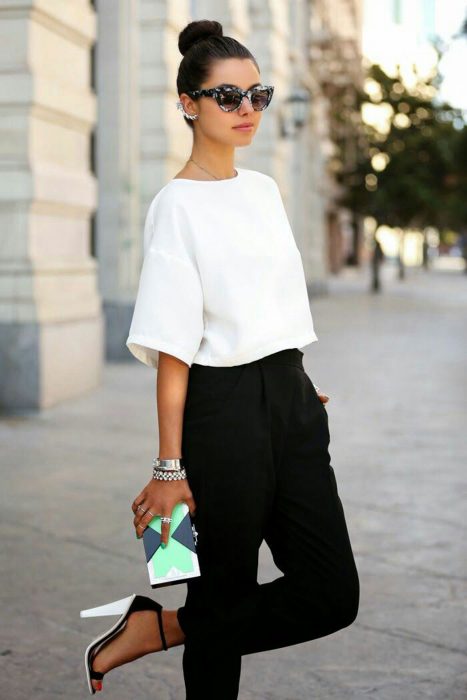 Chica usando un pantalón negro y una blusa blanca 