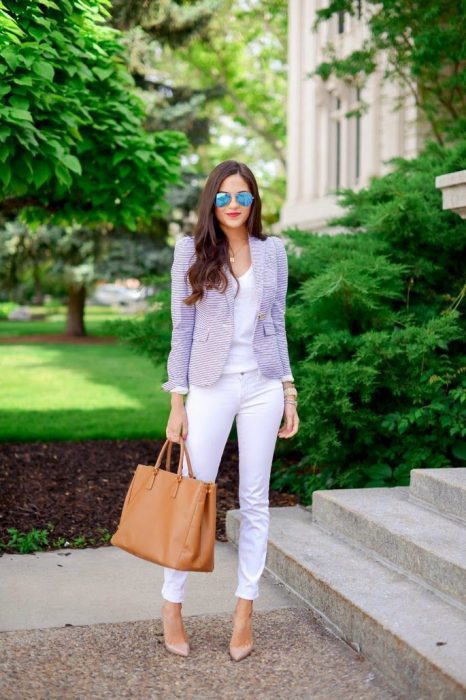 Chica vestida de blanco acompañando su outfit con un blazer en color lila 