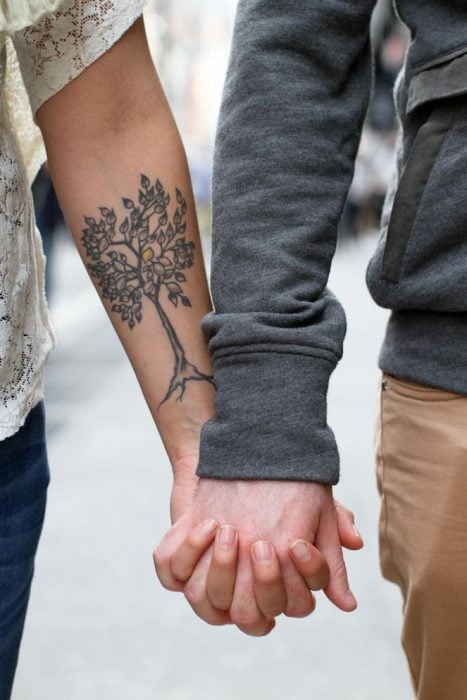 manos de pareja entrelazadas tatuaje árbol