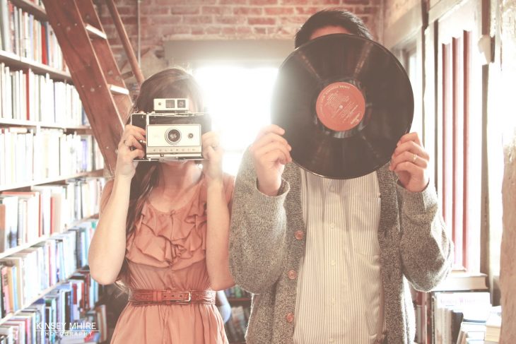 pareja chica con cámara vintaje chico con disco vinil