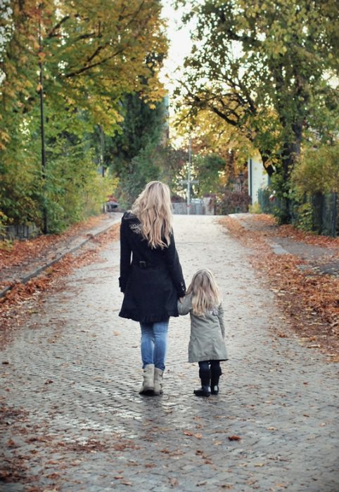 Chica y bebé caminando de la mano 