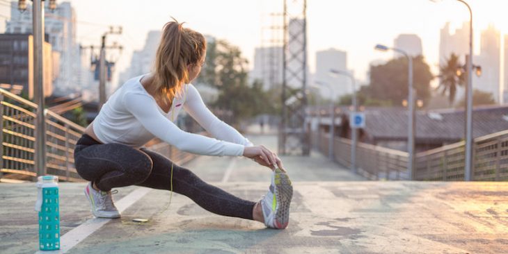 Chica estirando sus pies para ir a correr 