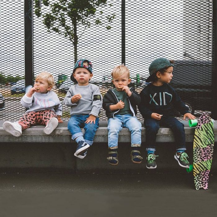 Niños sentados sobre una banca comiendo 