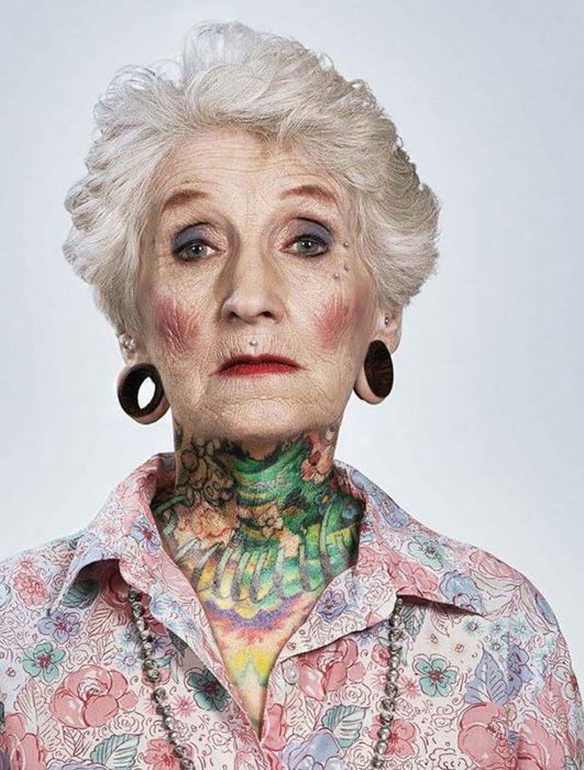 Mujer con tatuajes de edad mayor y expansiones en las orejas 