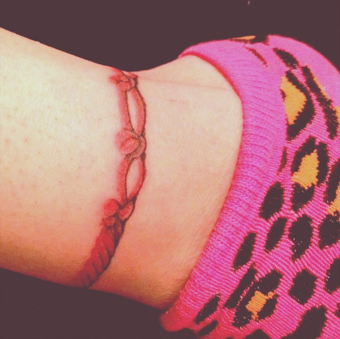 Tatuaje de pulsera roja en el pie 