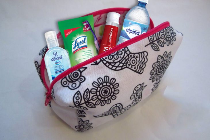 Bolsa cosmetiquera con distintos implementos de viaje