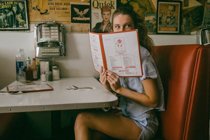 mujer rubia en restaurante con menú 