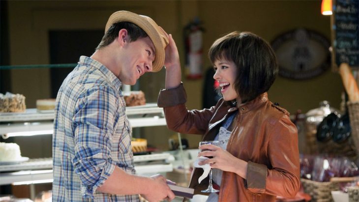 pareja en un café jugando con sombrero y sonriendo 