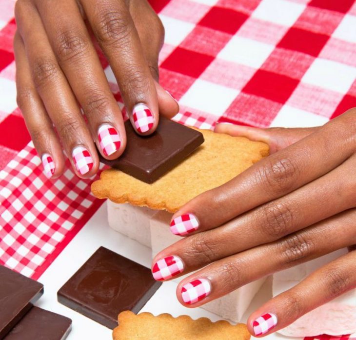 manos de mujer morena con diseño de cuadros rojos blancos y rosas y galletas