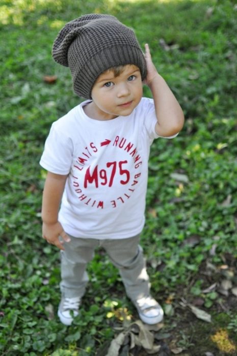 Niño mini fashionista vestido con un pantalón color gris, playera blanca y gorra color gris