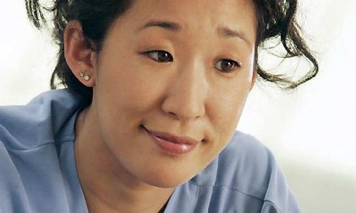 mujer ojos rasgados sonriendo con camisa azul 