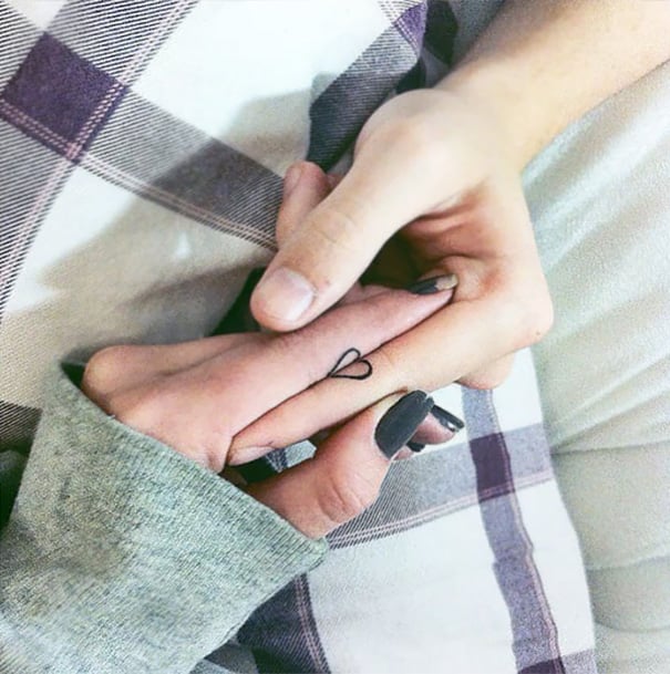Personas uniendo sus tatuajes que forman un corazón 