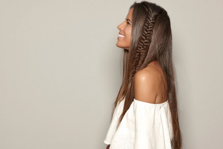 mujer morena con trenza de lado y cabello largo 