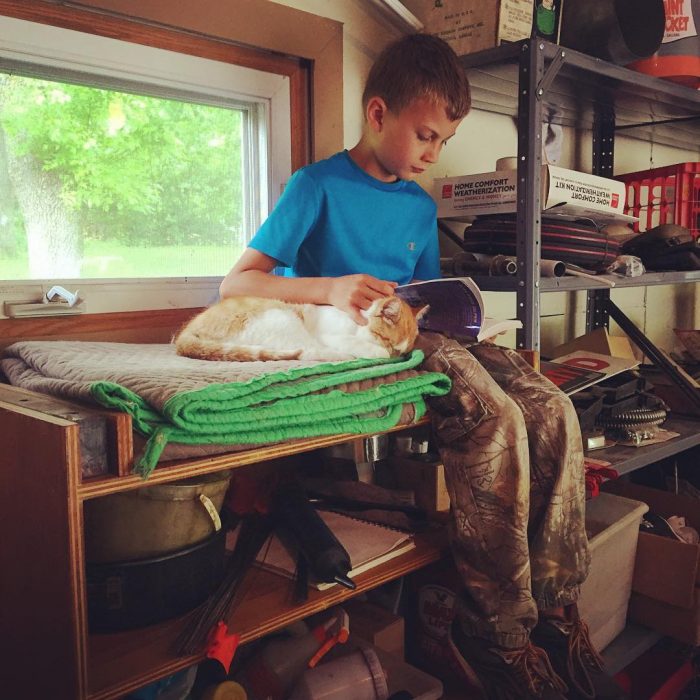 niño leyendo con gato en las piernas