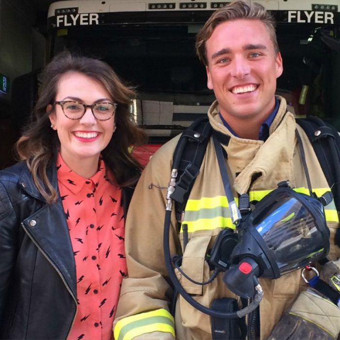 hombre bombero tomandose foto con mujer blanca de cabello negro 