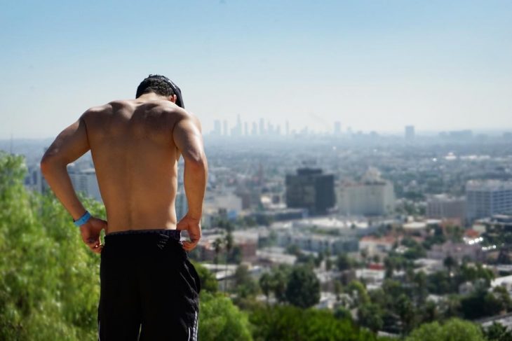 hombre musculoso sin playera de espaldas en la ciudad 