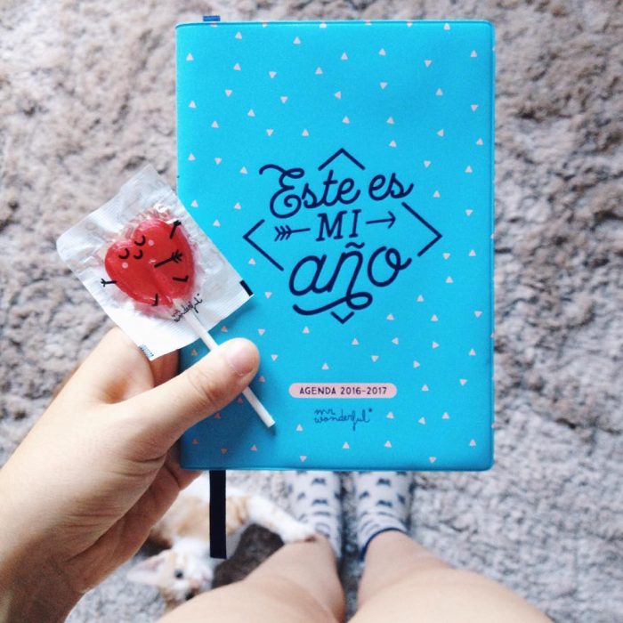 mujer con paleta roja y una agenda azul 