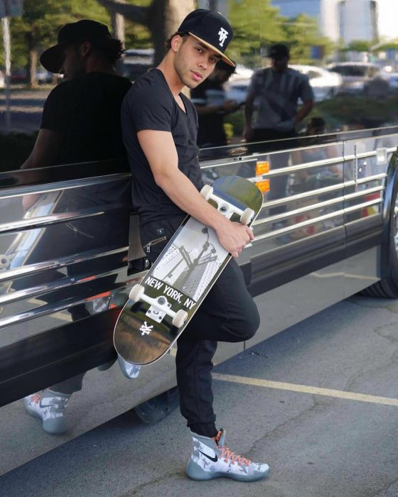 hombre con patineta recargado a lado de camion 