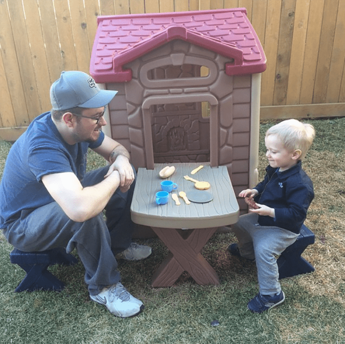 hombre con gorra sentado en mesa con niño 