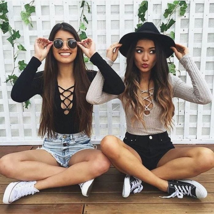 Chicas sentadas sobre un piso de madera usando la misma vestimenta 